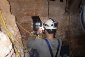 Technicien vérifiant le contrôle d’éclairage dans la grotte touristique