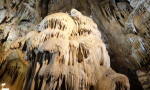 Beleuchteter Tropfsteinvorhang in der Aven Marzal mit warmweißem LED-Licht