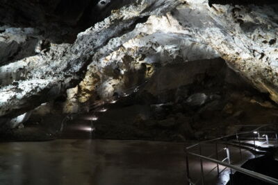 Illuminated water area with reflective rock structure in a Slovak cave