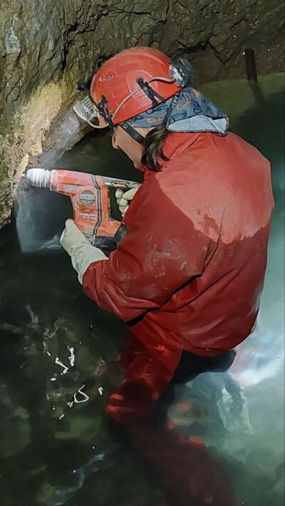 Technician installing LED lighting in cave water in Slovakia