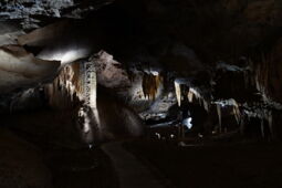 Illuminated corridor of the Prometheus Cave with stalactite columns