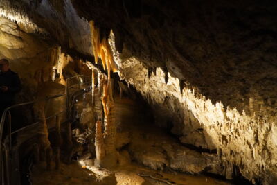 Close-up of stalactites and dripstone formations with warm LED lighting