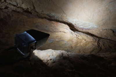 LED spotlight illuminating cave floor and rock structures