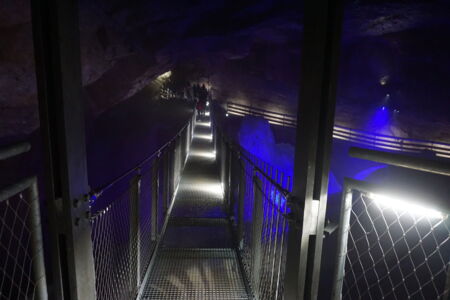 Passage de tunnel éclairée en bleu avec chemin sécurisé pour visiteurs – conception lumineuse atmosphérique de Cave Lighting